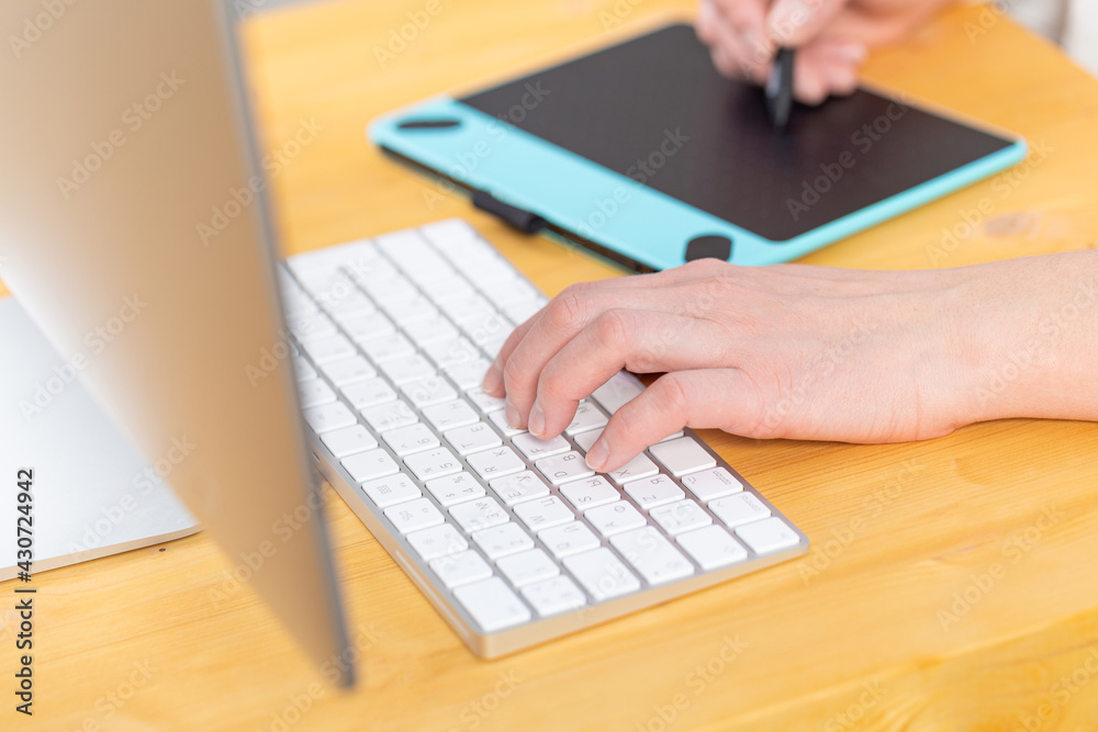 A graphic designer works on a digital tablet. work from home A graphic designer works on a digital tablet. work from home