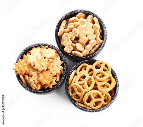 Bowls with tasty different crackers on white background © Pixel-Shot