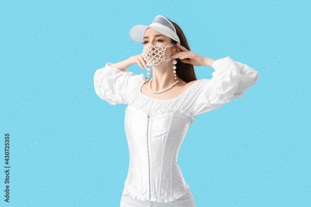 Fashionable young woman wearing mask on color background Fashionable young woman wearing mask on color background