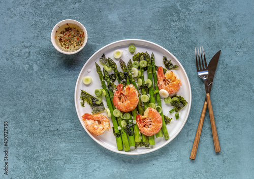 Seasonal salad from prawn shrimp, green asparagus, onion, and seaweed on a plate, festive appetizer, or buffet snack. Clean healthy eating.