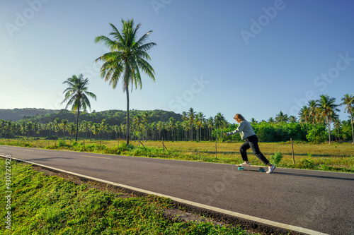 Yougn Asian Women Playing Surfskate on a road, in summer season © Songkhla Studio