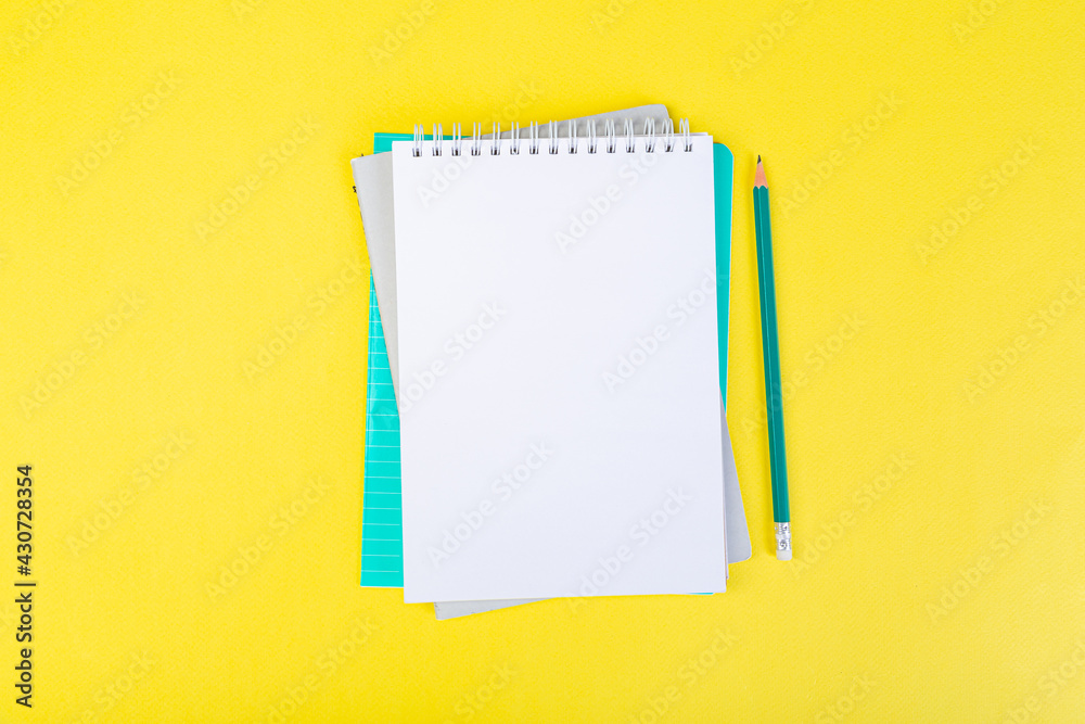 open notepad on yellow background with pencil on top, spiral notepad with blank sheet. open notepad on yellow background with pencil on top, spiral notepad with blank sheet.