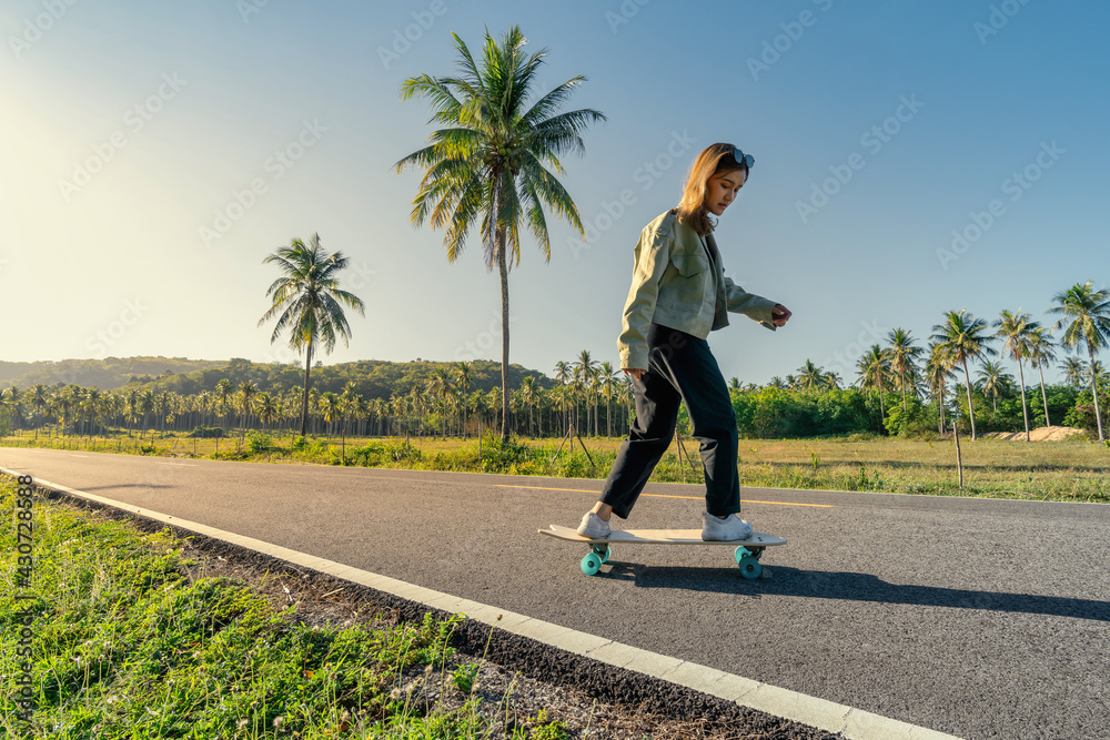 Yougn Asian Women Playing Surfskate on a road, in summer season