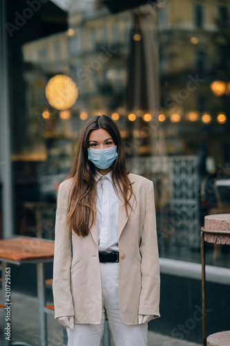 Young woman with face mask in the street © teksomolika