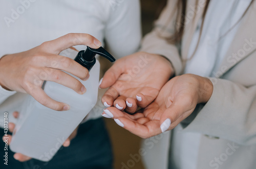 Female hands applying antibacterial liquid soap close up.