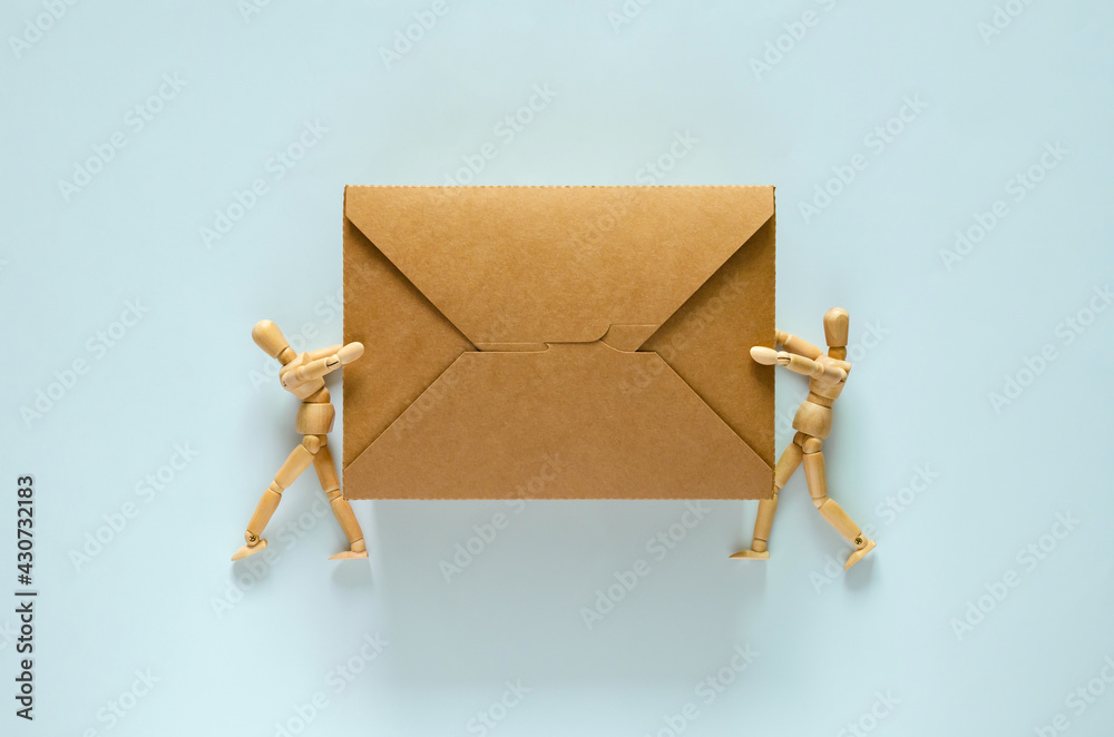 Fototapeta premium Two wooden models holding disposable, compostable paper food box for world environment day concept.