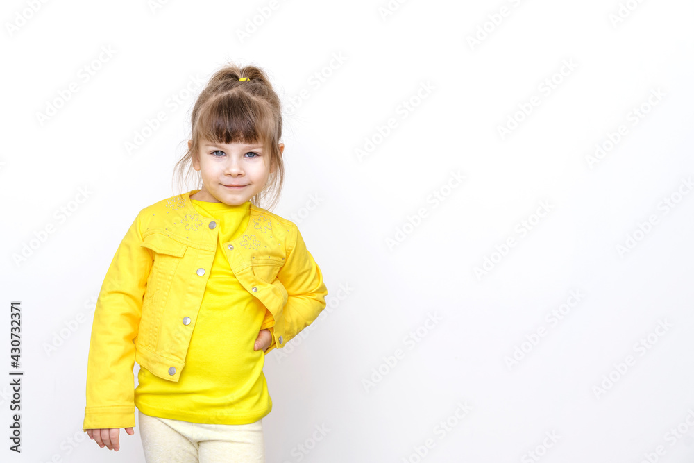 little girl in yellow clothes posing against gray wall background, copy space little girl in yellow clothes posing against gray wall background, copy space