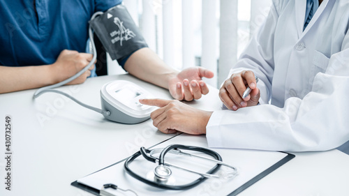 Doctor press blood pressure monitor to measure patient blood pressure