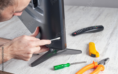 Caucasian engineer repairing Tv at home.