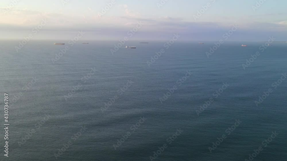 Landscape shot of ocean with freight ships seen in background