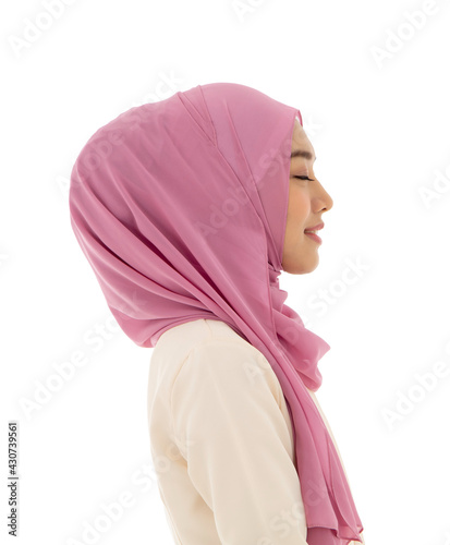 Side view portrait of asian islamic beautiful your female in pink hijab closing eyes and smiling isolated on white background with clipping path. Concept of hope and happy.