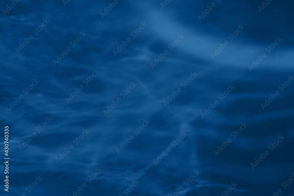 Trendy blue colored low contrast abstract background with light and shadows caustic effect. Light passes through a glass. Water background. 