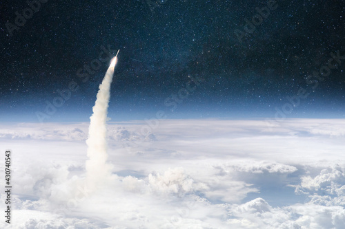 Fototapeta Naklejka Na Ścianę i Meble -  Rocket lift off through the clouds and flies into outer deep space. Spaceship successful launch. Planet earth from orbit