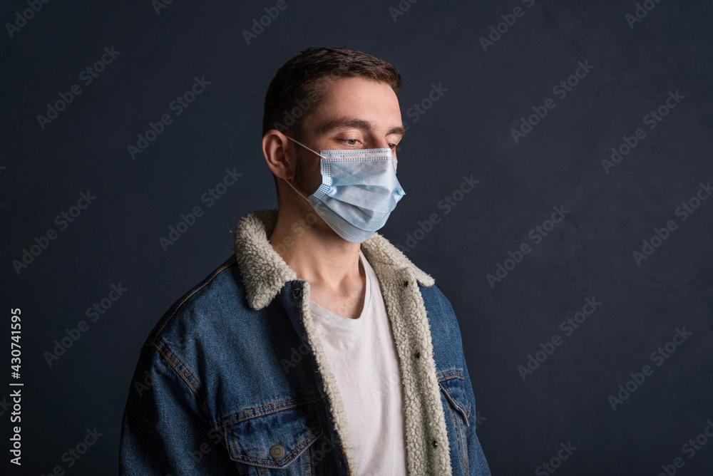 Portrait of a young man wearing a medical mask on a dark gray background to protect and stop viruses and the coronavirus pandemic, the outbreak of covid-19. Portrait of a young man wearing a medical mask on a dark gray background to protect and stop viruses and the coronavirus pandemic, the outbreak of covid-19.