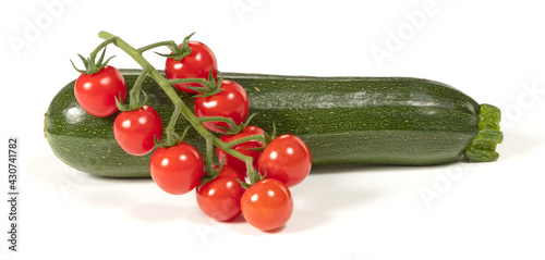 Twig of fresh cherry tomato and a zucchini, isolated