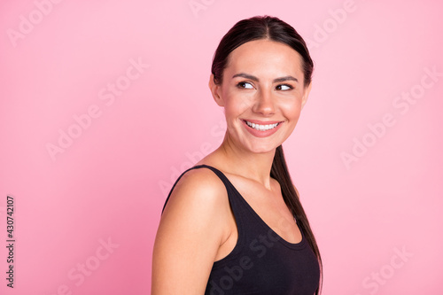 Profile side photo of young happy positive young woman look empty space smile dream isolated on pink color background