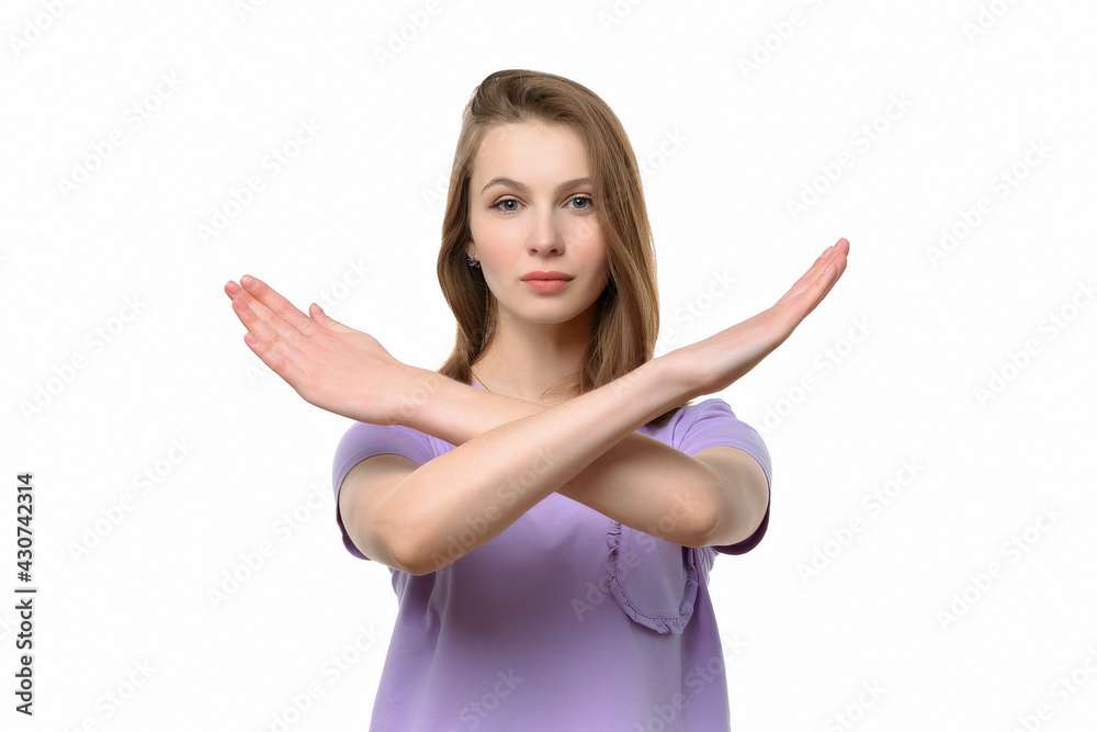 Serious young woman keeps two arms crossed, showing stop gesture while looking at camera. Denial concept Serious young woman keeps two arms crossed, showing stop gesture while looking at camera. Denial concept