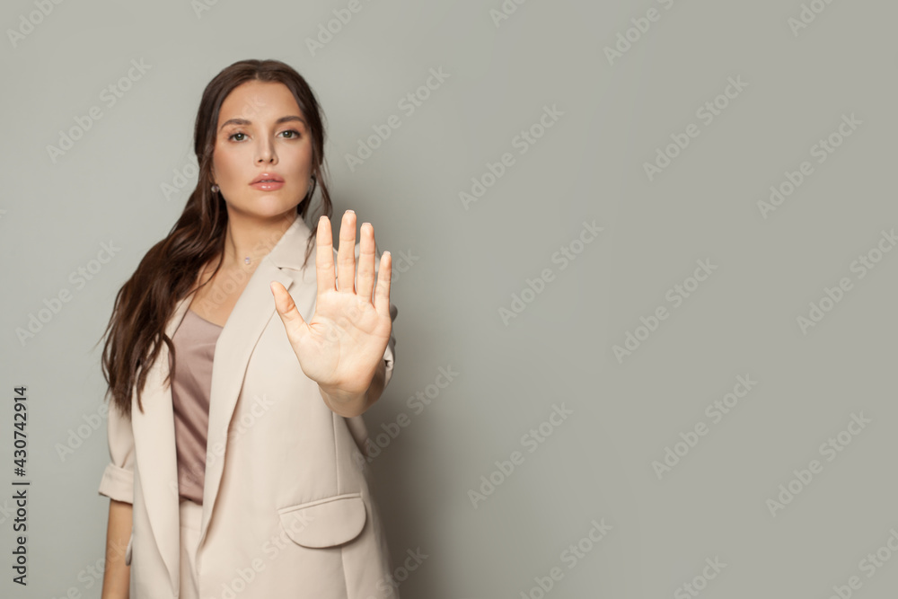Clever business woman showing stop gesture on gray banner background - obrazy, fototapety, plakaty 