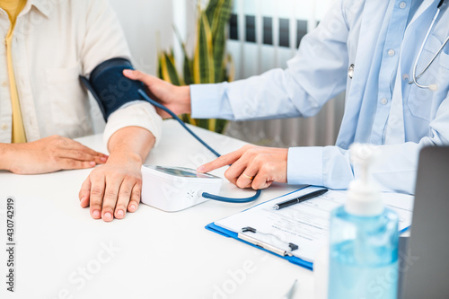 Doctor wear face mask comforting Measuring arterial blood pressurecare patient care, helping, encourage and empathy at nursing hospital ward After Corona virus epidemic.