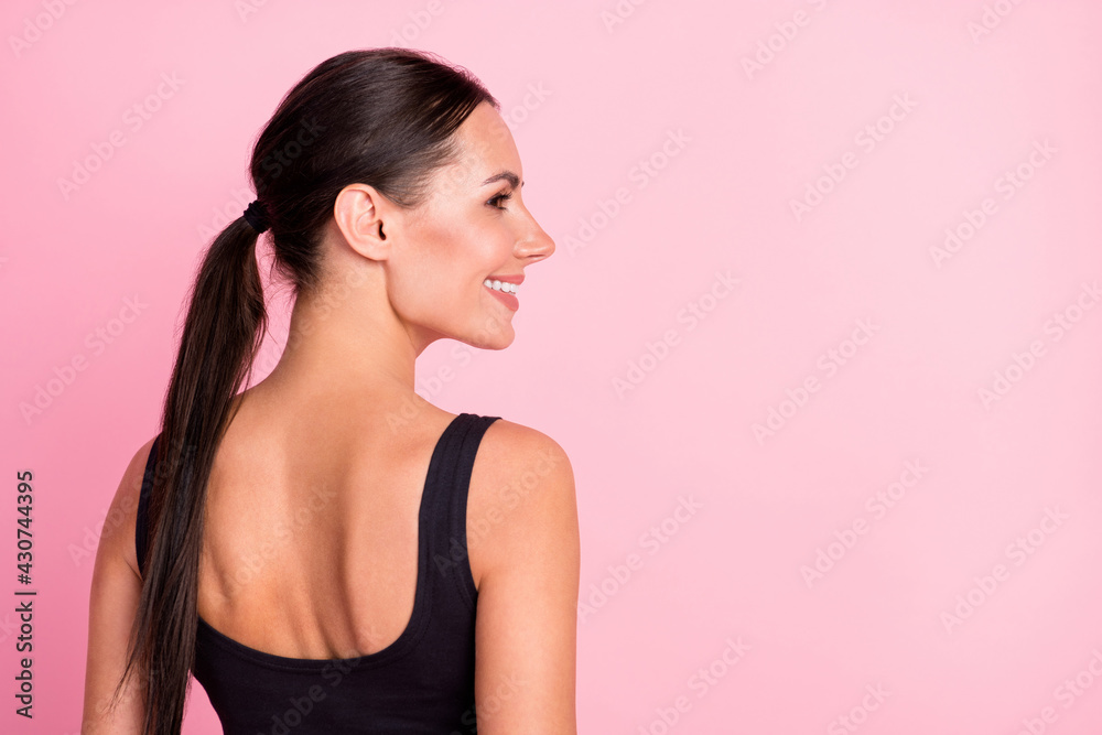 Photo of confident cheerful woman dressed sportive outfit standing back smiling looking empty space isolated pink color background Photo of confident cheerful woman dressed sportive outfit standing back smiling looking empty space isolated pink color background