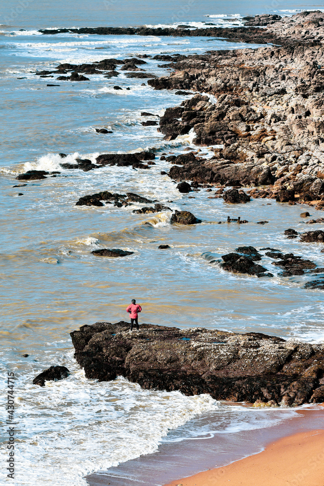 Wild Atlantic Ocean coastline in France and a man looking at it.