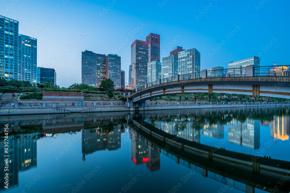 Business district office buildings and water reflection in Beijing at dusk Business district office buildings and water reflection in Beijing at dusk
