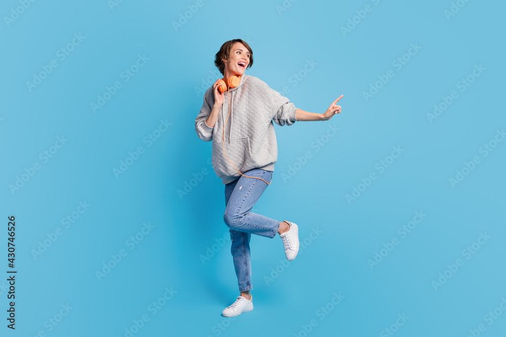 Full length body size view of attractive cheerful girl listening music dancing isolated over bright blue color background Full length body size view of attractive cheerful girl listening music dancing isolated over bright blue color background