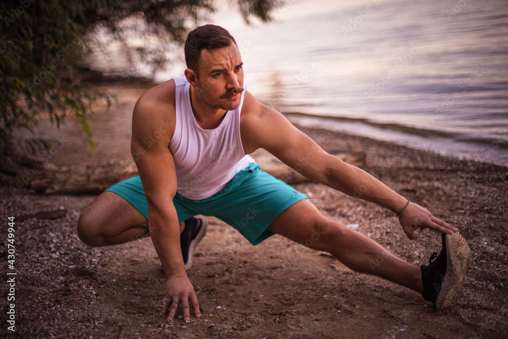 Fototapeta premium Young sports man working exercise on the beach.