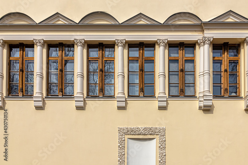 Schilderij op canvas Wooden windows with pilasters and a niche with floral ornaments on the wall of t