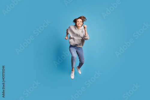 Full length body size photo of girl jumping up running fast on sale isolated vibrant blue color background