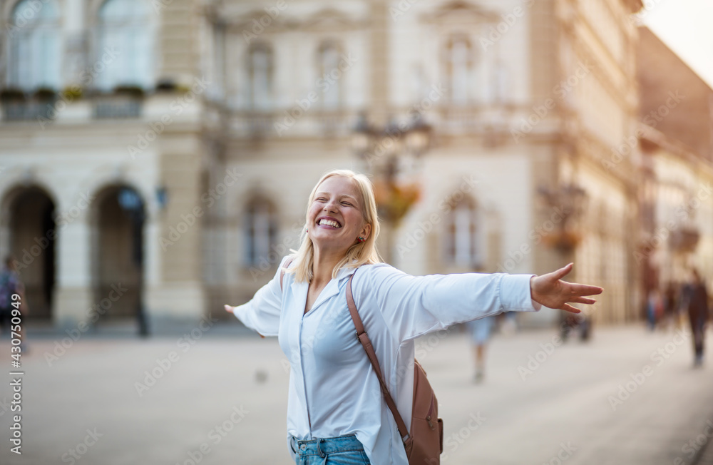 Fototapeta premium Happy woman with outstretched arms on the street.