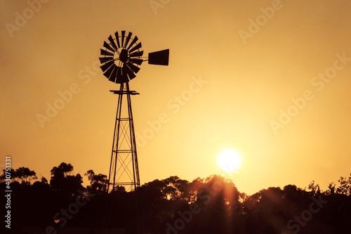 Silhouette of a windmill against the sunset