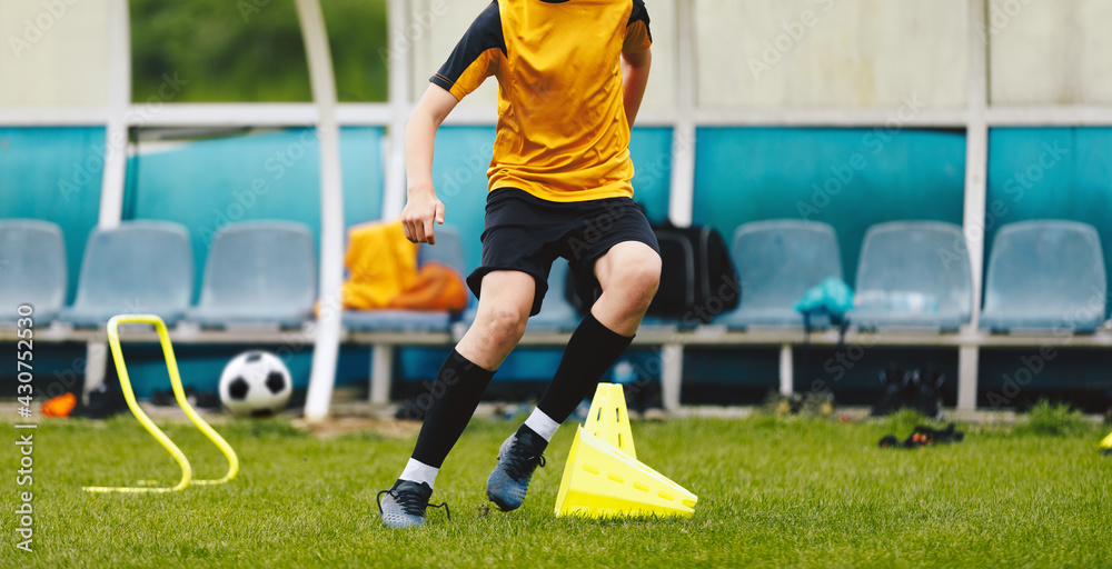 Teenage football player running on training pitch. Young boy practicing