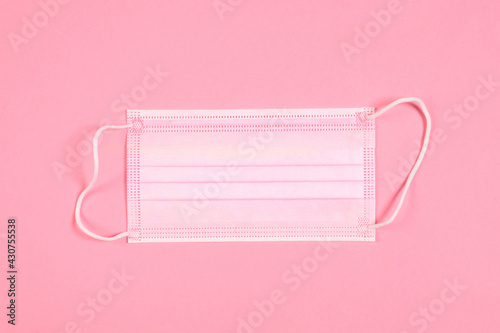 medical face mask on pink background with copy space for your text