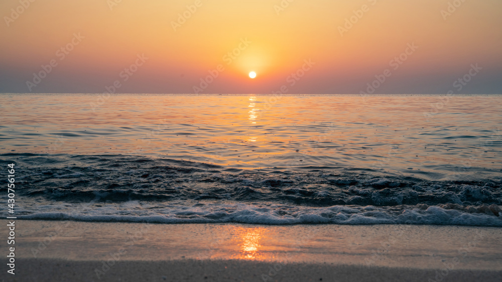 Naklejka premium Colorful vibrant ocean beach sunrise during a summer day. beautiful sunrise