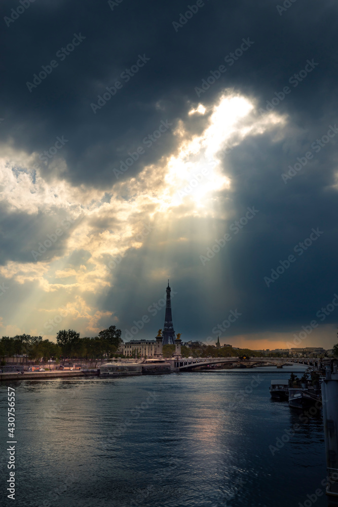 Paris, France - April 28, 2021: View from the river Seine of part of the Bridge of Alexander III and Eiffel Tower in Paris in the rays of the setting sun