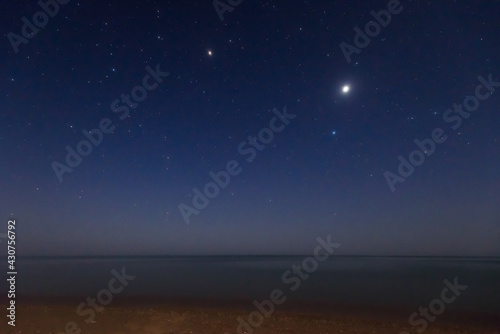 The planet Jupiter and bright stars Spica and Arcturus in evening twilight sky