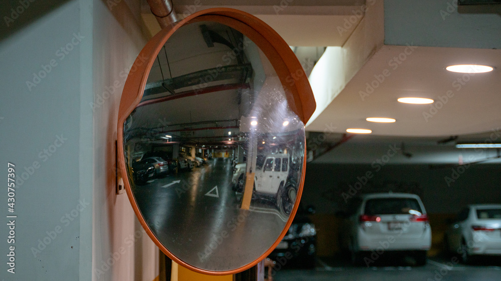Curve mirror at a basement parking.Traffic mirror safety and security concept. Selective focus