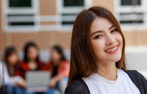 Young and beautiful Asian college student girls holding books, pose to camera with group of friends blur in background against school building. Learning and friendship of teens close friend concept Free Download Young and beautiful Asian college student girls holding books, pose to camera with group of friends blur in background against school building. Learning and friendship of teens close friend concept - GFXLoad