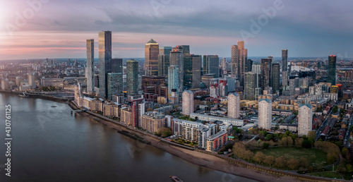 Panoramic view of the residential and commercial skyscrapers of Canary Wharf and the Docklands in London, United Kingdom, during sunset time © moofushi