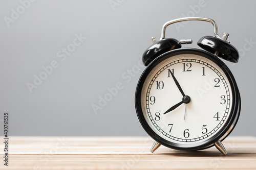Vintage alarm clock on wooden table background and copy space for text. Activity, daily routine, morning, workout and Work life balance concept