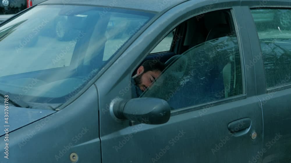 coexistence problems - young man sleeps in the car after arguing with his wife coexistence problems - young man sleeps in the car after arguing with his wife