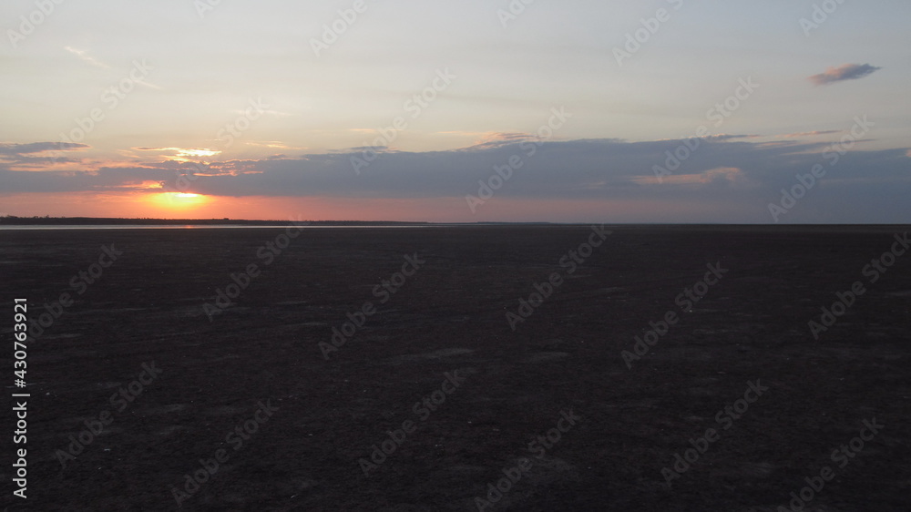 Zachód słońca daleko na horyzoncie latem - obrazy, fototapety, plakaty 