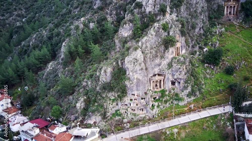 Drone view on world famous unesco Tomb of Amyntas in Fethiye. Rock cutted lucian empire tombs inside the green mountain
 photo