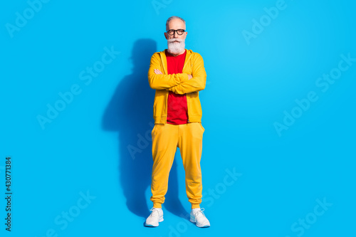 Full size photo of serious cool confident mature businessman with folded hands isolated on blue color background