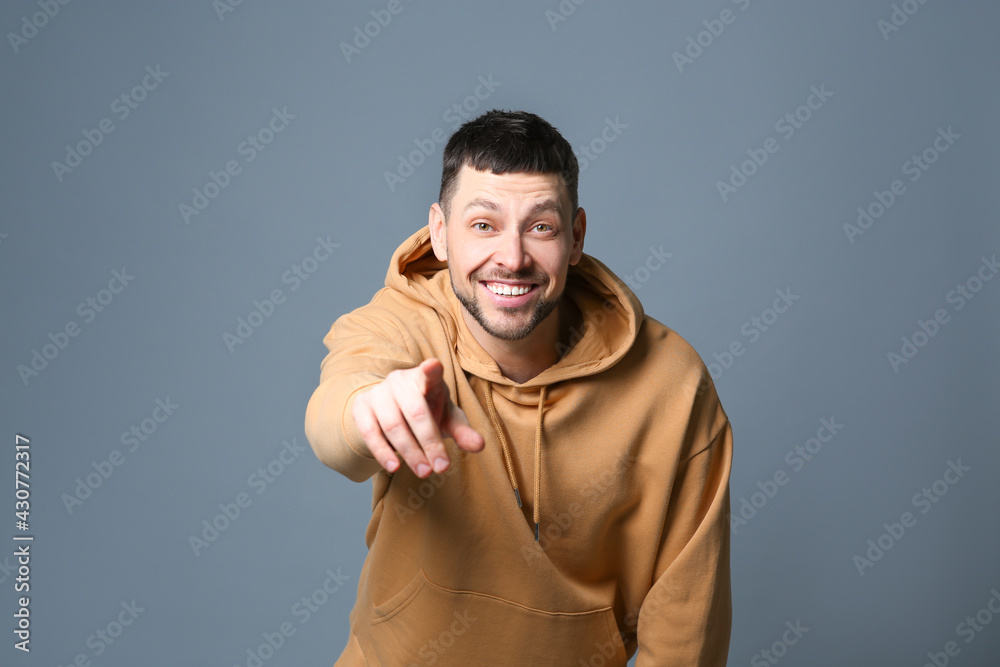 Fototapeta premium Handsome man laughing on grey background. Funny joke