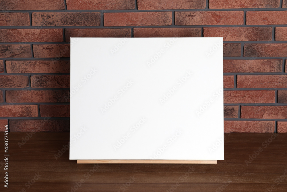 Wooden easel with blank canvas on table Wooden easel with blank canvas on table