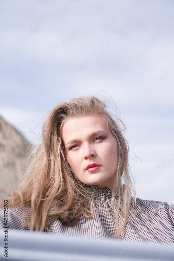 Beauty portrait of a young blond girl in a vintage dress. She is posing on a sandy landscape. Beauty portrait of a young blond girl in a vintage dress. She is posing on a sandy landscape.