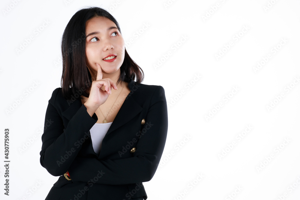 Young and cute businesswoman in black suit poses in thinking gesture and looking to blank space Young and cute businesswoman in black suit poses in thinking gesture and looking to blank space