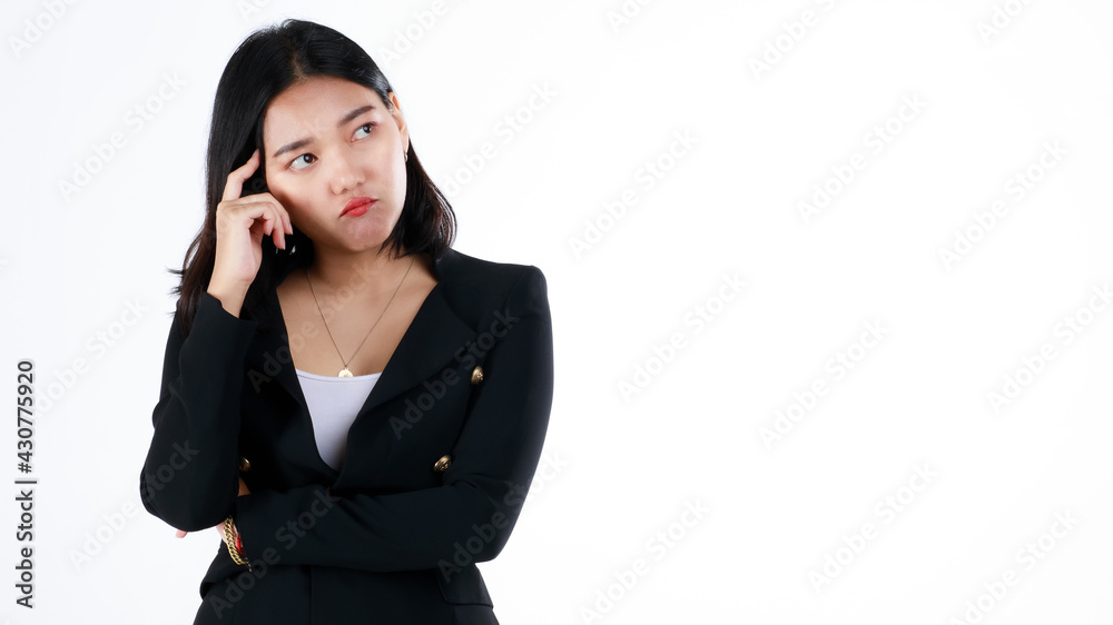 Young and cute businesswoman in black suit poses in thinking gesture and looking to blank space Young and cute businesswoman in black suit poses in thinking gesture and looking to blank space